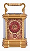 France, a large and extremely decorative carriage clock with grand sonnerie striking, unusual gilt Anglaise variant case with twist columns having Corinthian capitals and turned bases, the molded base and cornice with bowed sides and conforming beveled glasses, top with twist ornamented handle matching the columns, red guilloche enamel dial with convex chapter and gilt Arabic numerals, ornate pierced and chased, gilt dial mask with lily of the valley ornament, gold hands, 8 day time, strike, and alarm movement with lever platform and cut bimetallic balance, sounding grand or petit quarters in passing, and repeating the last hour and quarter on demand, serial #1304, with original leather bound box and key