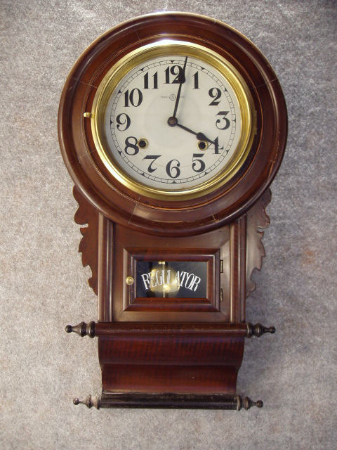 This A Japnanese Scroll Bottom Style School Clock In A Brown Adamantine Type Finish. Circa 1910-1920. — Antique Clocks Price Guide