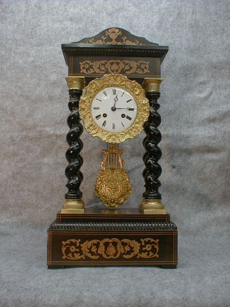French Empire Clock In A Walnut And Ebony Case With Satinwood Marquetry With Barley Twist Columns That Have Gilt Caps And Bases. — Antique Clocks Price Guide