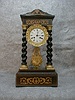 French Empire Clock In A Walnut And Ebony Case With Satinwood Marquetry With Barley Twist Columns That Have Gilt Caps And Bases.