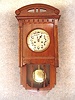 German "Berliner" Style Wall Clock With An Encased Bottom And Original Top Piece In A Walnut Veneered Art Deco Style Case, By The Hamburg American Clock Co. Circa 1910-1920.