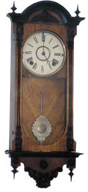 Miniature Vienna type, wall regulator. It is only 25 inches high, walnut case with ebony finials, carvings, and trim. — Antique Clocks Price Guide
