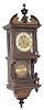 Hamburg American wall regulator in a free swinger type case, where the pendulum is hanging behind a glass door.