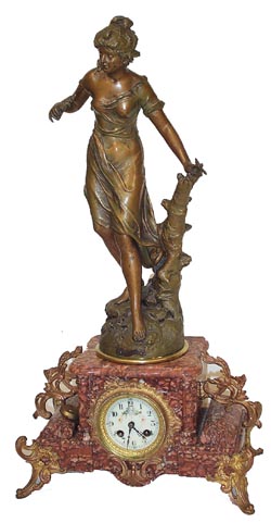 French statue on marble base. Cast bronze ornaments on the base, including the 4 elaborate feet and the large dial surround. — Antique Clocks Price Guide