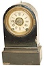 Terry Clock Co. enameled iron case, 8" high. 30 hour, time, strike, and alarm.