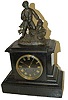 French black slate dial and clock case with attached statue of a boy, or man, out tooting his horn.