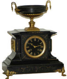 French black marble with gold-filled etchings on the front of the case; bronze frieze scenes on each side, of a woman and a cupid; gilt paw feet and bronze urn ornaments. — Antique Clocks Price Guide