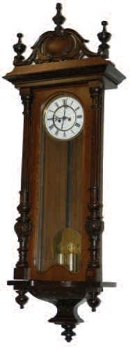 German Vienna Regulator, 2 weights, in a walnut veneered case, 51 inches tall. The door has turned, fluted, and carved half columns. — Antique Clocks Price Guide