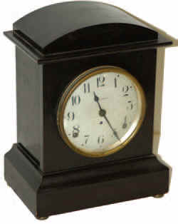 Seth Thomas mantle clock, "Dana" model in a wood case with a mahogany adamantine finish, stands 11 inches tall. — Antique Clocks Price Guide