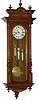 Vienna Regulator, 3 weights, 8 day quarter hour striking movement. The 49 inches walnut case is near mint, has half columns that are carved and turned, 3 good glasses, pendulum, and weights.