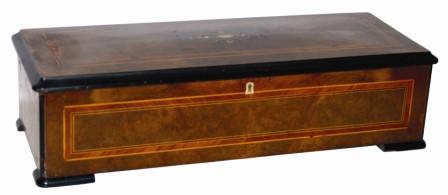 Swiss cylinder music box with a 13" cylinder, it has no broken teeth, a good comb with zither attachment, and double mainspring barrels. It plays eight recognizable tunes including some waltzes and marches. — Antique Clocks Price Guide