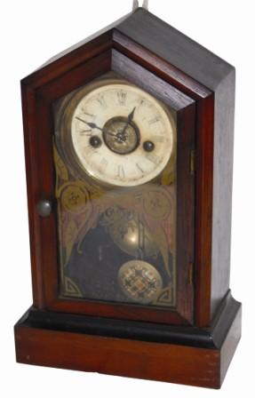 Cottage clock, possibly German. There is a black label on the base but I cannot read it, and the backboard, inside, is covered with oil cloth paper. — Antique Clocks Price Guide