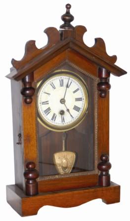 German mantle clock. 16" high walnut case has several wood ornaments and turnings, also ripple around the door. — Antique Clocks Price Guide
