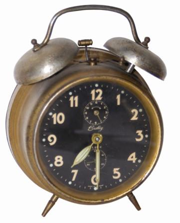 German alarm clock, "Bradley". Metal case is 6.5" high, tarnished, good glass, dial, and hands. — Antique Clocks Price Guide