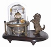 Novelty clock featuring a cat and animated fish. The brass case rests on a wood base.