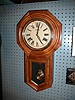 Walnut finished pine case eight-day "Schoolhouse" clock with strike on the hours.