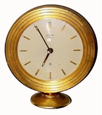 C.1955, Swiss, LeCoultre, Desk Alarm clock, 8-day, luminous hands, with alarm aperture below 12. — Antique Clocks Price Guide