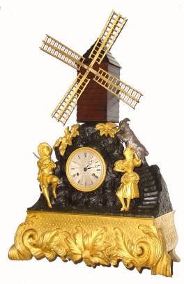 C.1880, French, Automaton Figural clock, the dial marked LeRoy, Paris, with a windmill powered by a separate movement in the base, and a bag-piper piping while a costumed girl to the right is dancing, and behind a silvered goat is eating flowers. — Antique Clocks Price Guide