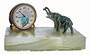 C.1920, Swiss, ÓLe petit ForgeronÒ, desk novelty. In a heart shaped opening in the bottom of the dial sits a little winged cherub making iron arrows at the anvil. His hammer is attached to the lever beneath the dial and appears to hit the anvil with every tick. A little spelter elephant is mounted to the marble base and appears to be looking at the time. 