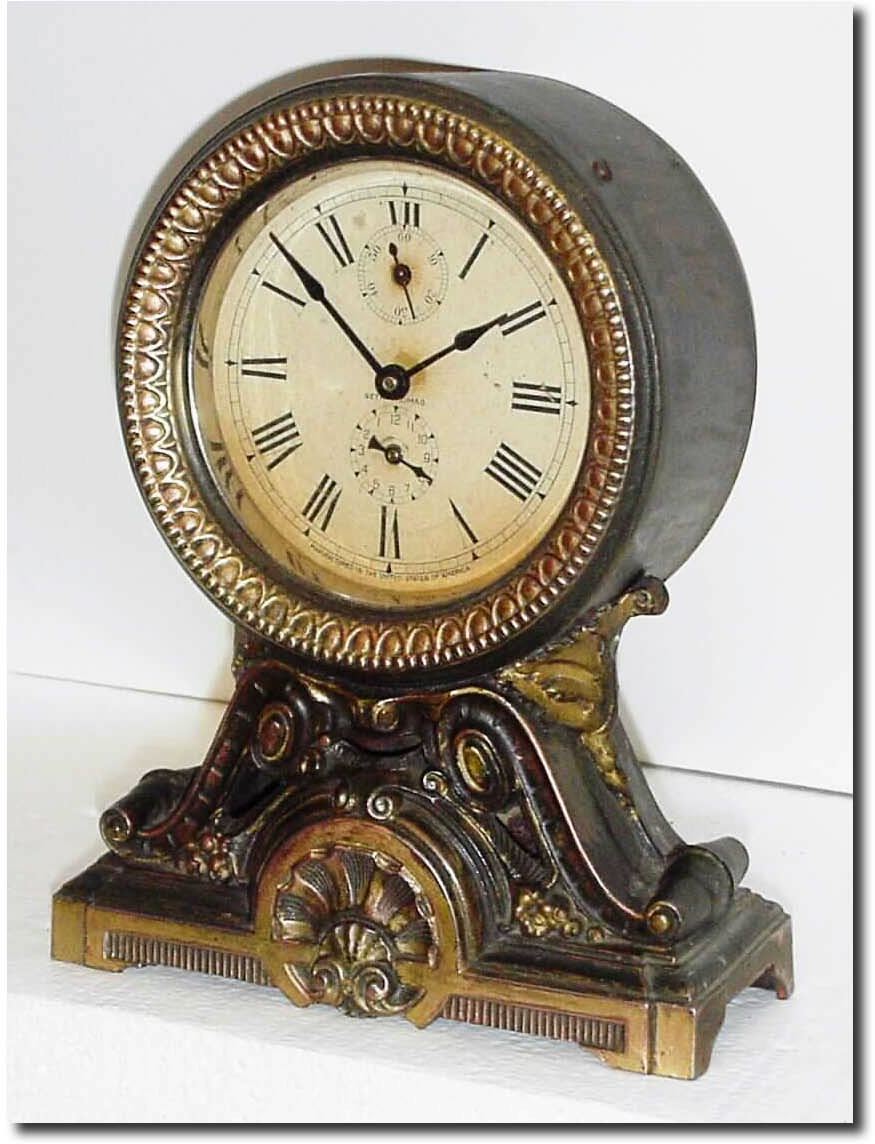 C.1910, Seth Thomas "Long Alarm', the top a pressed brass canister and the base of spelter with antique finish. — Antique Clocks Price Guide