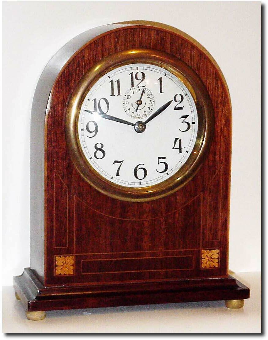C.1920, English Alarm Clock in a mahogany round gothic case with satinwood and floral inlay, the base molding setting on 4 brass bun feet. — Antique Clocks Price Guide
