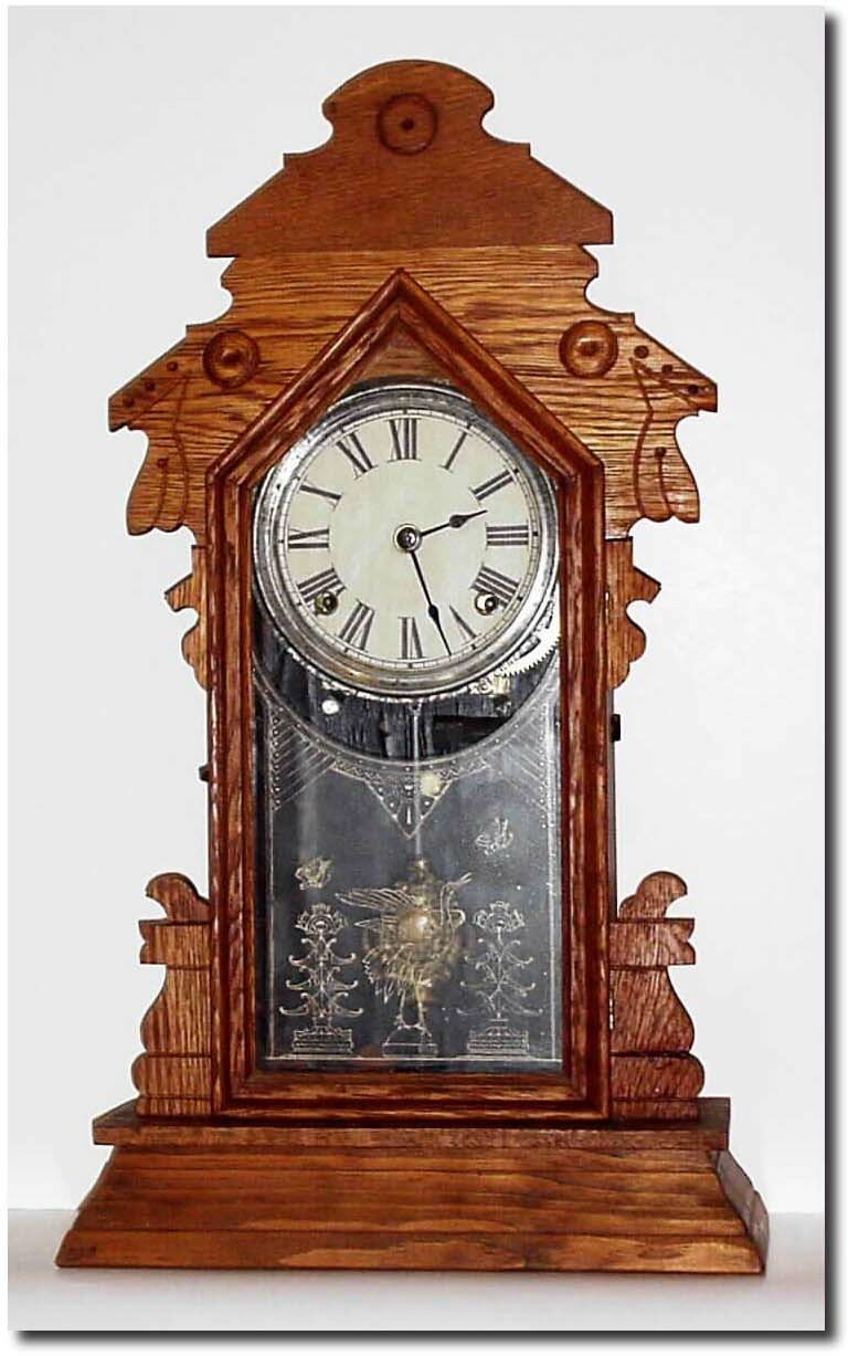 C.1900, Mixed lot: An Ingraham oak kitchen clock case, with replaced top and bottom moldings, poorly refinished and with a new tablet, NOW with an Gilbert 8-day movement, repapered dial, and incorrect gong. — Antique Clocks Price Guide
