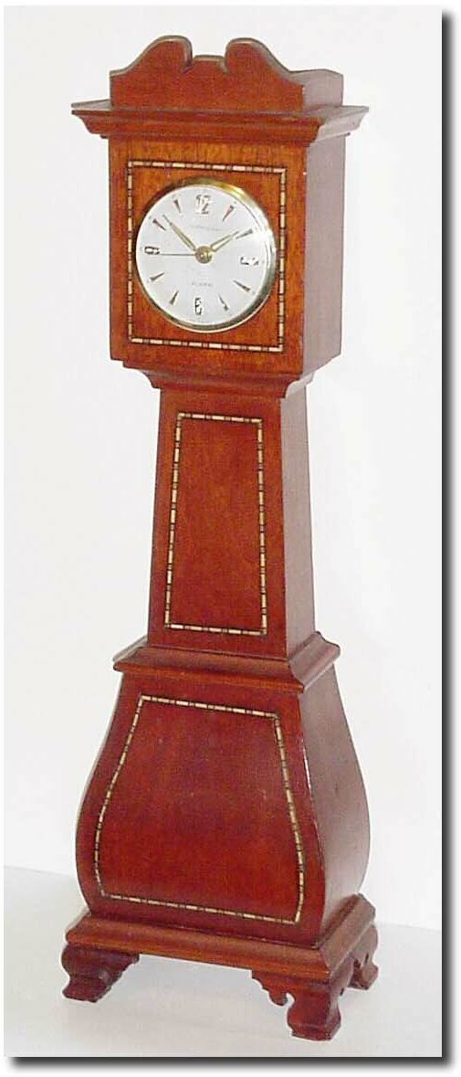 C.1950, A German 30-hour "over-ocean' alarm clock, now in a purpose made broken arch "tall' case from the same period, by a handy cabinet maker, with cross banded inlay on the bombay base, trunk and hood. — Antique Clocks Price Guide