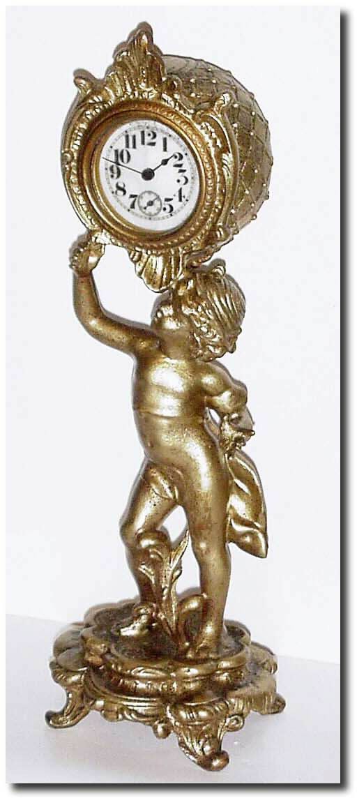 C.1910, An American, Ladies Boudoir Clock, a young lad supporting a basket above, housing a small lever movement with porcelain dial. — Antique Clocks Price Guide
