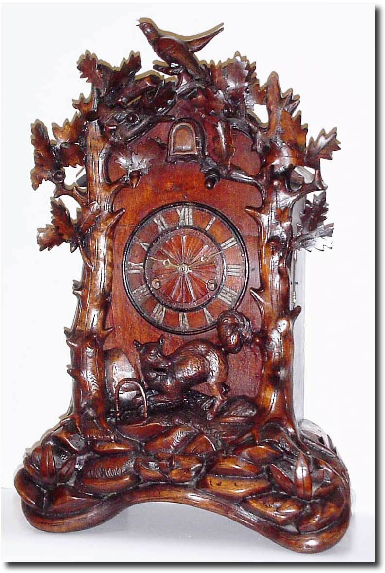 C.1900, German, Black Forest Shelf Cuckoo in well carved case showing a fox caught in a trap in the woods, surrounded by oak branches, oak leaves and acorns, and a cuckoo bird at the apex. — Antique Clocks Price Guide