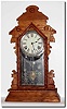 C.1900, Mixed lot: An Ingraham oak kitchen clock case, with replaced top and bottom moldings, poorly refinished and with a new tablet, NOW with an Gilbert 8-day movement, repapered dial, and incorrect gong.