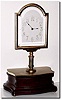 C.1900, French, Mahogany and Gilt Brass Mystery Mantel timepiece. The 5 inch beveled glass dial with smooth bezel , raised on a fluted pillar; the rectangular plated movement with platform lever escapement, and driving the hands without apparent connection.