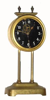 C.1921, English GRAVITY clock, the clock driven by its own weight, and raised each day along a ratcheted upright, and with exposed escapement and compound bar-bell pendulum — Antique Clocks Price Guide