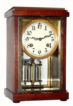 C.1915, Waterbury Clock Co., "Tavernes", 8-day time/strike "crystal regulator", glass front and rear, wood sides. — Antique Clocks Price Guide