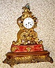 C.1840, French, Fanciful mantel clock on a gilt wood base [no dome], the embossed brass case accented with porcelain flowers [some missing].