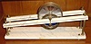 C.1974 (dated) George Dorne's Clepsydra, No. 9, marble base with bronze uprights and brass cylinder with plexi-glass partitions, the blue liquid and the force of gravity on the incline providing the motive force.