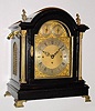 C.1890, English, 3-Fusee, 8-Bell Quarter chime bracket clock, in the style of a century earlier, an ebonized case with gilt columns and flame finials.