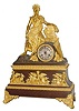 C.1840, French, Ormolu and Bronze Clock, commemorating the Revolutions in South America beginning in 1810, an Indian figure, left arm resting on a stone pillar with 4 countries listed: Etats Unis (US), Colombia, Mexico and Peru, the chieftain with a feather head dress, chain in his/her right hand, and a lion skin draped over the left shoulder, 8-day bell strike movement with silvered dial.