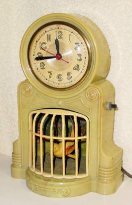 C.1940, Mastercrafters Clock and Radio Co., Chicago, BIRD ON SWING automaton timepiece, 110v, yellow parakeet swinging vigorously swinging in front of a village scene. — Antique Clocks Price Guide
