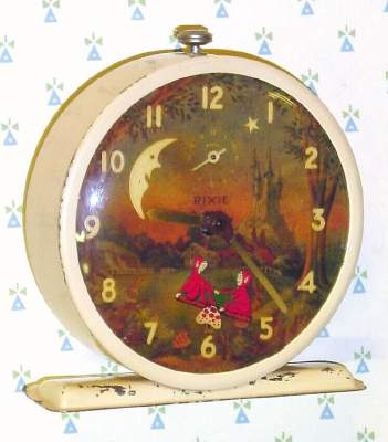 C.1946, Canada, "Pixie", 30-hour novelty alarm timepiece (2 Pixies in red clothes are rocking on a teeter totter). — Antique Clocks Price Guide
