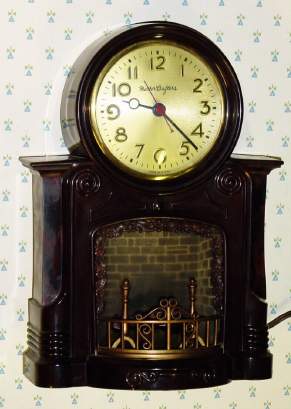 C.1948, MasterCrafters Clock Corp., Chicago, FIREPLACE , 110v timepiece, with bright red fire appearing to burn the fireplace below the dial. — Antique Clocks Price Guide