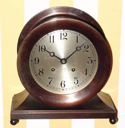 C.1951, Chelsea Clock Co., Boston, Mass., "Base and Ball" , 8-day ship's bell clock, 6" dial, serial number 567253 in a bronze finish case retailed by "J. E. Caldwell and Co" (on dial). This model was also known as the "Commodore" and the "Constitution" over the years. — Antique Clocks Price Guide