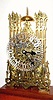  C.1890, English, 2-Chain-Fusee Skeleton Clock, striking the hours on a large coiled wire gong and the halves on a bell at top, and with fine 5-spoke wheels throughout, in a glazed case of mahogany and beveled glass. 