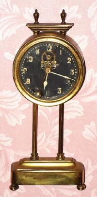 C.1900, English, Gravity Clock, round brass canister contains movement, driven by its own weight when lifted on two columns with side teeth. — Antique Clocks Price Guide
