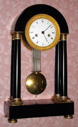 C.1800, French, Empire Pinwheel regulator, with grid pendulum, black marble portico style case with 4 columns w/ top and bottom ormolu capitals, and with vernier beat set. — Antique Clocks Price Guide