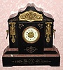 C.1890, French, Black Slate and Bronze mantel clock, 8-day time and gong strike, with porcelain dial, with fancy bronze center. 