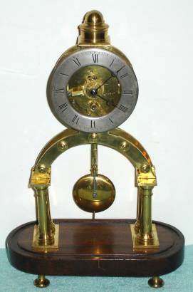 C.1870, French, small skeleton timepiece, on an oval wooden base, no dome. — Antique Clocks Price Guide