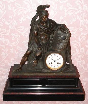 C.1900, French, Marti and Cie, 8-day time and bell strike bronze and marble figural mantel clock. Translation of the Greek inscription on the scroll the warrior is holding reads: "Having given up your weapons, take up other things", idiomatic translation: "Turn from War to Learning". — Antique Clocks Price Guide