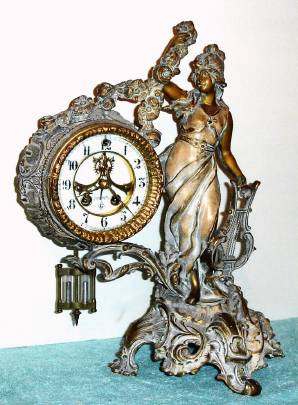 C.1913, William L. Gilbert Clock Co., "Beatrice", 8-day time/strike figural mantel clock, exposed escapement and pendulum. — Antique Clocks Price Guide