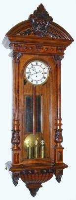 C.1875, Austrian, 3-Wt, Grand Sonnerie wall clock in walnut, with 3/4 columns, nicely carved and with original top bearing the face of the Northwind. — Antique Clocks Price Guide