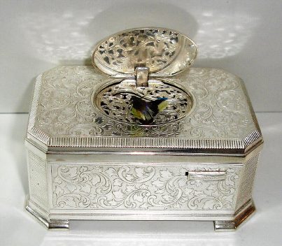 Late 20 the Century, German, Singing Bird box, in a silver plate over embossed brass case, with a mechanical key wound bird singing at will, when front slide is pushed to the right. — Antique Clocks Price Guide
